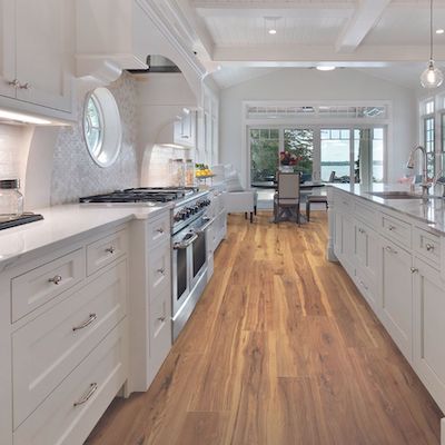 wood look laminate flooring in a bright open kitchen with white cabinets